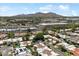 An aerial shot showcasing a neighborhood with pools, palm trees, and commercial buildings in the distance at 7319 E Rose Ln, Scottsdale, AZ 85250