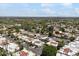 Expansive aerial view showcasing a neighborhood with a mix of green trees and white rooftops under a bright blue sky at 7319 E Rose Ln, Scottsdale, AZ 85250