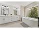 Bathroom featuring a double vanity, tub and a large window with nature view at 7319 E Rose Ln, Scottsdale, AZ 85250