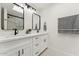 Bathroom with modern double vanity, sinks, mirrors and lighting fixtures at 7319 E Rose Ln, Scottsdale, AZ 85250
