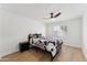 Bedroom featuring a ceiling fan, hard wood floors and large window with shutters at 7319 E Rose Ln, Scottsdale, AZ 85250