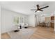 Bright living room featuring wood floors, white walls, shutters, and modern ceiling fan at 7319 E Rose Ln, Scottsdale, AZ 85250