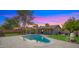 Aerial view of backyard with a pool, manicured lawn, trees, and a charming home at 7543 E Portland St, Scottsdale, AZ 85257