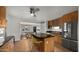 Open kitchen with stainless appliances, breakfast bar, and view to dining room at 7543 E Portland St, Scottsdale, AZ 85257