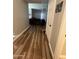 Hallway with wood-look flooring leading to a living room and bedrooms at 7725 W Mcrae W Way, Glendale, AZ 85308
