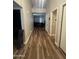 Long hallway with wood-look floors leading to the living area at 7725 W Mcrae W Way, Glendale, AZ 85308