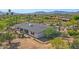 Expansive aerial view of desert home featuring a flat roof, covered patio, and natural desert landscaping and mountain views at 8049 E Serene St, Carefree, AZ 85377