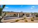Rear exterior view of a charming desert home with a covered patio and desert landscaping at 8049 E Serene St, Carefree, AZ 85377