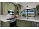 Updated kitchen showcasing green cabinetry, stainless steel appliances, and a bright window for natural light at 8049 E Serene St, Carefree, AZ 85377