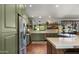 A gourmet kitchen featuring green cabinets, stainless steel appliances, and an island with bar seating at 8049 E Serene St, Carefree, AZ 85377