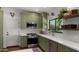 Charming kitchen boasts green cabinetry, stainless appliances, and a window with natural light at 8049 E Serene St, Carefree, AZ 85377