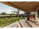 View of the covered patio with outdoor seating, backyard, and perimeter fencing at 8566 N 108Th Ln, Peoria, AZ 85345