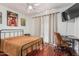 Bright bedroom with hardwood floors and a ceiling fan also features a desk and tv at 8566 N 108Th Ln, Peoria, AZ 85345