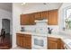 Bright kitchen features wood cabinetry, white countertops and appliances and a window for natural light at 8566 N 108Th Ln, Peoria, AZ 85345