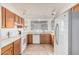 Well-lit kitchen showcasing wood cabinets, white countertops and appliances, and a window over the sink at 8566 N 108Th Ln, Peoria, AZ 85345