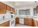 Bright kitchen has wooden cabinets, white countertops, and a window that brings in plenty of natural light at 8566 N 108Th Ln, Peoria, AZ 85345