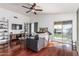 Bright living room with rich wood floors, vaulted ceiling, comfortable seating, and backyard views at 8566 N 108Th Ln, Peoria, AZ 85345