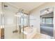Modern bathroom featuring a soaking tub, glass-enclosed shower, and tile flooring at 1037 E Baylor Ln, Gilbert, AZ 85296