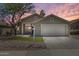 Charming single-story home featuring a well-maintained yard and a spacious two-car garage at sunset at 1037 E Baylor Ln, Gilbert, AZ 85296