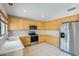 Well-lit kitchen features stainless steel appliances, light wood cabinetry, and ample counter space at 1037 E Baylor Ln, Gilbert, AZ 85296