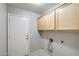 Clean laundry room with overhead cabinets, a door, and connections for appliances at 1037 E Baylor Ln, Gilbert, AZ 85296