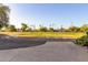 View from patio to community green space with fire pit and mature trees at 10516 W Peoria Ave, Sun City, AZ 85351