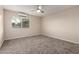 Bright bedroom with neutral carpet, ceiling fan, window, and modern A/C unit at 10516 W Peoria Ave, Sun City, AZ 85351