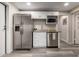 Well-equipped kitchen with stainless steel appliances, white cabinets, and an adjacent dining area at 10516 W Peoria Ave, Sun City, AZ 85351