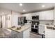 Modern kitchen featuring white cabinetry, stainless steel appliances, and an island with seating at 10516 W Peoria Ave, Sun City, AZ 85351