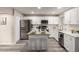 Contemporary kitchen featuring stainless steel appliances, white cabinets, and stylish island seating at 10516 W Peoria Ave, Sun City, AZ 85351