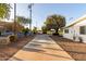 Exterior home shot with lush trees and a large sidewalk at 10516 W Peoria Ave, Sun City, AZ 85351