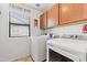 Bright laundry room with modern washer and dryer, cabinets, and a window at 1124 E Jahns Dr, Casa Grande, AZ 85122