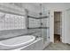 Luxurious soaking tub with custom tilework, glass-enclosed shower, and ample natural light at 11257 E Reginald Ave, Mesa, AZ 85212