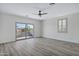 Spacious bedroom with light walls, balcony access, ceiling fan, and wood-style flooring at 11257 E Reginald Ave, Mesa, AZ 85212