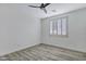 This bedroom has a ceiling fan, a window with shutters, and wood-look floors at 11257 E Reginald Ave, Mesa, AZ 85212
