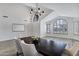 Elegant dining space with high ceilings, stylish chandelier, large windows, and wood-look flooring at 11257 E Reginald Ave, Mesa, AZ 85212