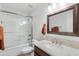 Bathroom features a shower-tub combo, a single sink with a large decorative mirror at 14981 W Robson N Cir, Goodyear, AZ 85395