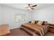 Bedroom features a large window with plantation shutters, ceiling fan and a queen bed at 14981 W Robson N Cir, Goodyear, AZ 85395