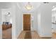 Inviting entryway featuring a wooden front door, tiled floor, and adjacent office and kitchen areas at 14981 W Robson N Cir, Goodyear, AZ 85395
