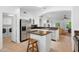 Bright kitchen featuring stainless steel appliances, white cabinets, tile flooring, and an island with stool at 14981 W Robson N Cir, Goodyear, AZ 85395