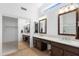 Bright main bathroom with and sinks, tile floor, quartz counters and mirrors at 14981 W Robson N Cir, Goodyear, AZ 85395