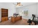 Office with carpet, a ceiling fan, plantation shutters, and a large wood desk at 14981 W Robson N Cir, Goodyear, AZ 85395