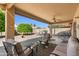 Covered patio with outdoor seating area overlooking the desert landscaped backyard at 14981 W Robson N Cir, Goodyear, AZ 85395