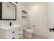 A modern bathroom features wood look tile flooring, sleek black hardware, shiplap accent wall and floating shelves at 1621 N Chippewa Dr, Chandler, AZ 85224