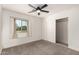 This bedroom features neutral carpet, a ceiling fan, closet, and a window seat overlooking the front yard at 1621 N Chippewa Dr, Chandler, AZ 85224
