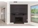 Close-up of modern fireplace with black shiplap surround, contrasting the light tile flooring at 1621 N Chippewa Dr, Chandler, AZ 85224
