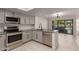 Updated kitchen featuring stainless steel appliances, gray cabinets, granite countertops, and backyard access at 1621 N Chippewa Dr, Chandler, AZ 85224