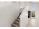 A carpeted staircase leads to the upper level, showcasing a clean and bright interior with wood-look tile flooring at 1621 N Chippewa Dr, Chandler, AZ 85224