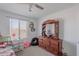 Bright bedroom with a window, dresser with mirror, and additional storage space with a small pink toy car at 1744 W Hopi Dr, Coolidge, AZ 85128