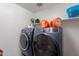 Modern laundry room features high-end, front-loading washer and dryer with storage shelves at 1744 W Hopi Dr, Coolidge, AZ 85128